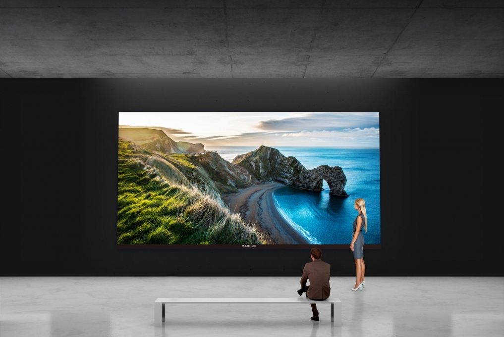 Woman standing by large video wall