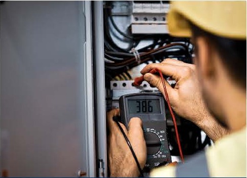 Technician testing low-voltage cabling in an equipment enclosure