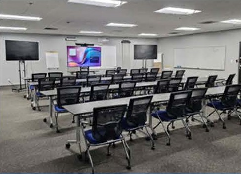 Training room with rows of tables and dual displays